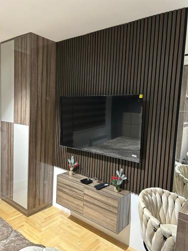 a living room with a large television on a wall at Studio Vučko in Pale