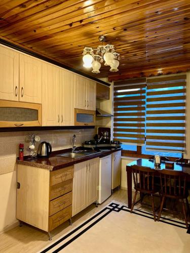 a kitchen with wooden cabinets and a table and a tableablish at Isgobya Sumela Monastery 102 in Macka