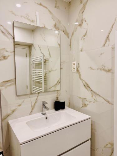a white bathroom with a sink and a mirror at Skyline Duplex Brussels Parking Fibre Modernité in Brussels