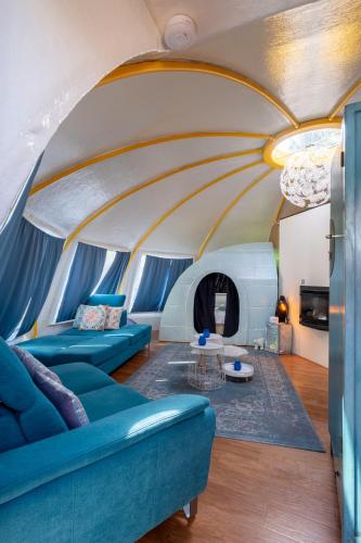 a living room with blue furniture in a tent at LOFT Groepsaccommodatie in Boxum