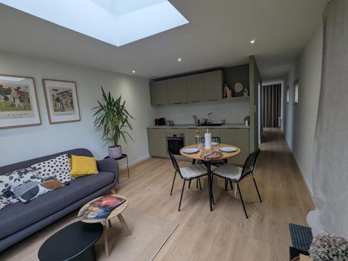 ein Wohnzimmer mit Sofa und Tisch in der Unterkunft Logement Indépendant - à proximité de Lille in Lambersart