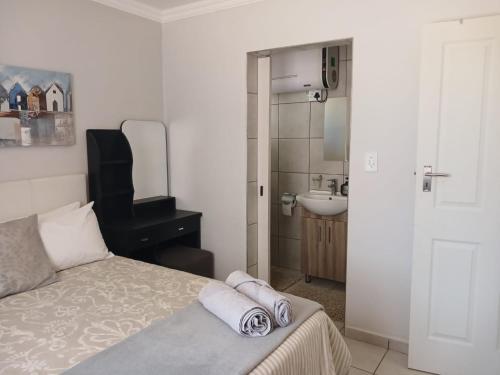 a bedroom with a bed and a sink and a mirror at Karoo-Hart in Orania