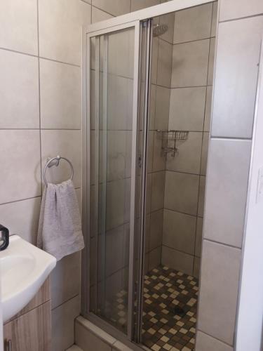 a shower with a glass door in a bathroom at Karoo-Hart in Orania