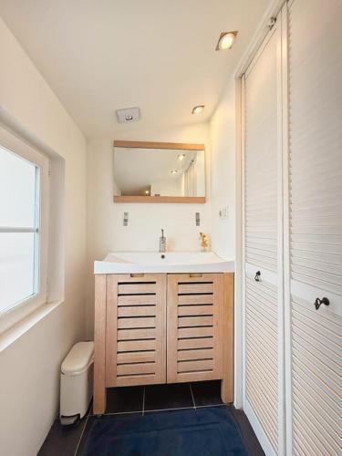a bathroom with a sink and a toilet and a mirror at Coeur Rochelais, Atypique, centre, 5 min du port in La Rochelle