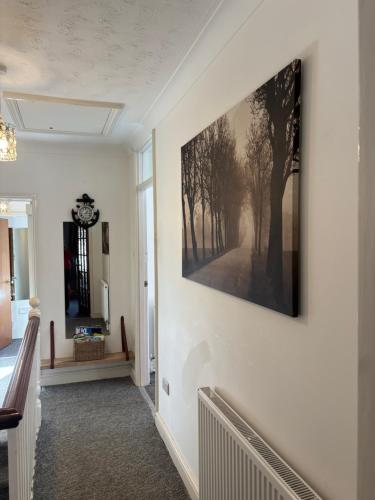 a hallway with a painting hanging on a wall at Hockham in King's Lynn