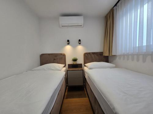 2 Betten in einem Krankenhauszimmer mit Fenster in der Unterkunft Osijek LUXURY Center Apartment - self check in, 2 parking spaces, balcony, elevator in Osijek