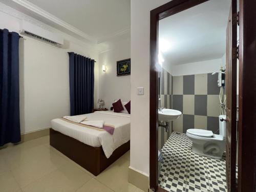 una camera da letto con un letto, un lavandino e un WC di Spacious Khmer Villa - Pool - Fast Wi-Fi a Phumĭ Réach Born
