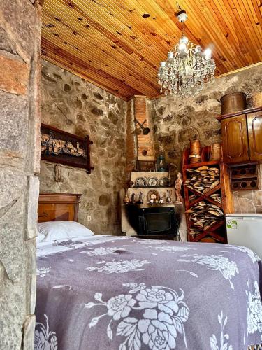 a bedroom with a bed in a stone room with a chandelier at Isgobya Sumela Monastery 104 in Macka