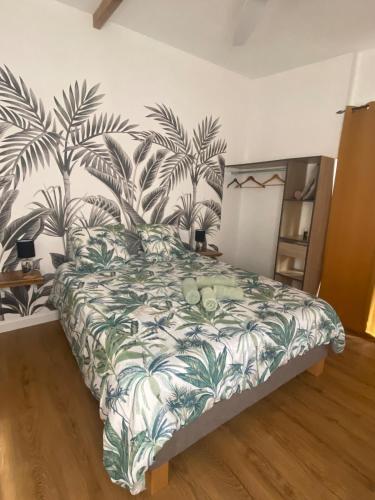 a bedroom with a bed with a tropical print on the wall at Chez Sylvie et Philippe in Entre-Deux