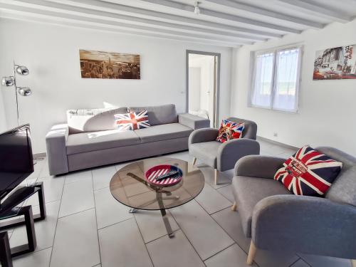 een woonkamer met een bank, stoelen en een tafel bij Gîte de la Petite Forge in Clévilliers