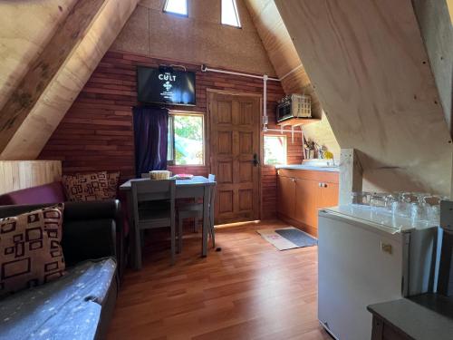 een keuken en een woonkamer met een tafel in een huisje bij las cascadas in Puerto Clocker