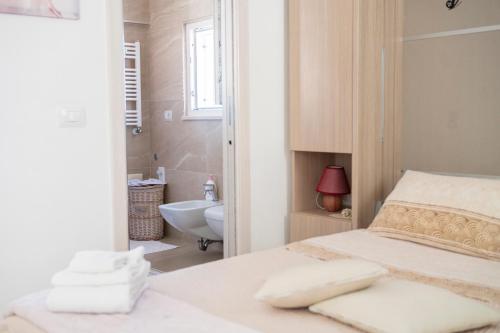een slaapkamer met een bed en een badkamer met een wastafel bij Pietra di Luna relaxing private terrace in Polignano a Mare