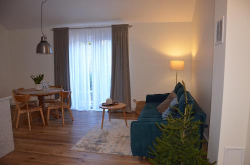 een woonkamer met een blauwe bank en een tafel bij Spokojnia in Lubrza