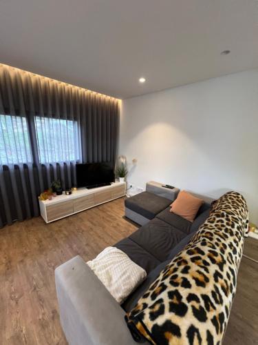 a living room with a leopard patterned couch and a living room with at Apartamento T2 - Leiria in Leiria