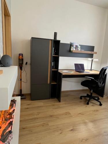 un ufficio con una scrivania e un frigorifero nero di Ferienwohnung Lengenfeld a Lengenfeld