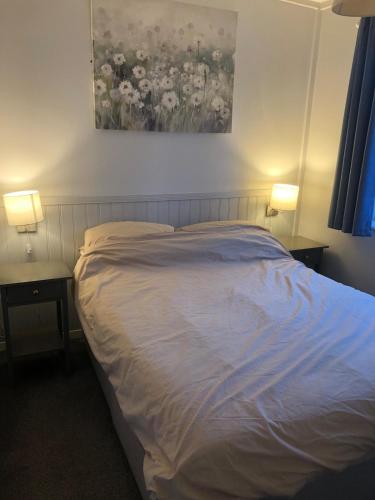 a bedroom with a bed and two tables with lamps at Seafields Chalet in Walcott
