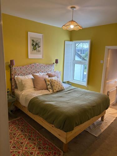 a bedroom with a large bed in front of a window at 2 Bed Terrace Cottage with Cathedral Views in Salisbury