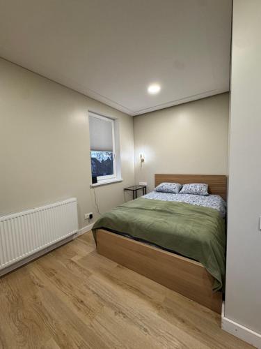 una camera da letto con un letto e una finestra di Greenhill a Kaunas