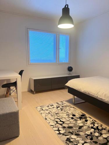een slaapkamer met een bed, een bureau en een raam bij Villa Blacksmith in Rovaniemi