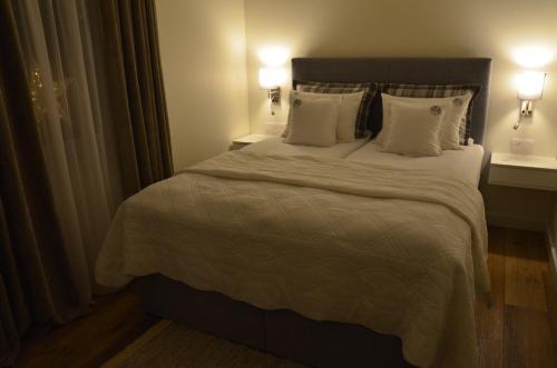 een slaapkamer met een groot bed met witte lakens en kussens bij Spokojnia in Lubrza