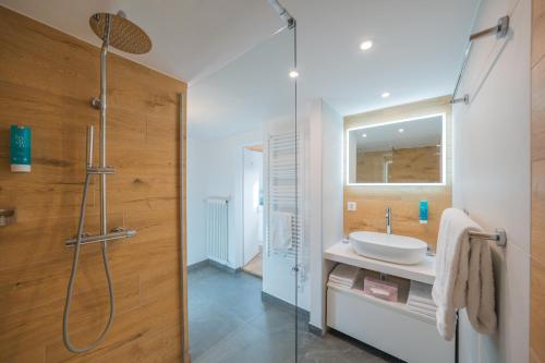 een badkamer met een wastafel en een douche bij Hotel Haus am Waldrand in Flims