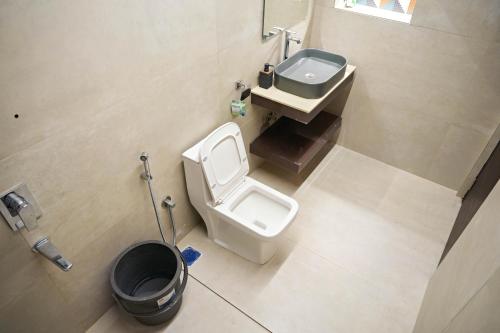 a bathroom with a toilet and a sink at Luxe poolside farmhouse -J House in Hyderabad