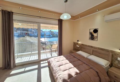 a bedroom with a bed and a large window at Minos Apartments in Skala Marion