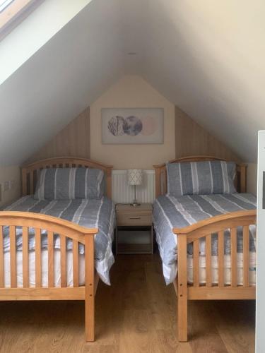 two beds in a room with a attic at Fenniscourt Cottage in Carlow
