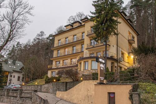 een groot geel gebouw met een trap ervoor bij Boży Dar in Krynica Zdrój