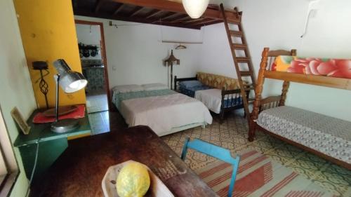 een kamer met 2 stapelbedden en een tafel bij Sitio Flor do Coriscão Paraty in Paraty