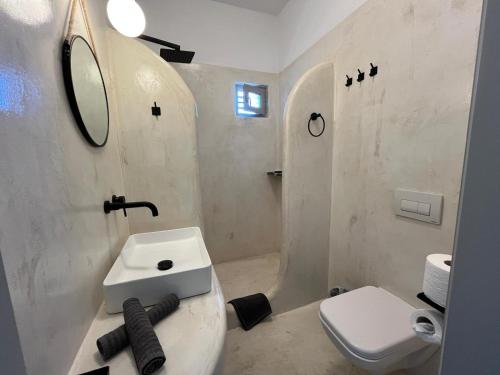 un bagno bianco con lavandino e WC di L Apothiki a Ios Chora