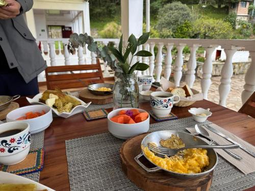 une table recouverte de bols de petit-déjeuner sur une véranda dans l'établissement Hacienda El Castillo Hotel Boutique, à Pasto