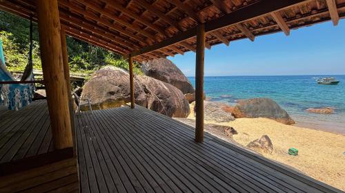een uitzicht op het strand vanaf de veranda van een huis bij Chalé Pé na Areia Por do Sol in Paraty