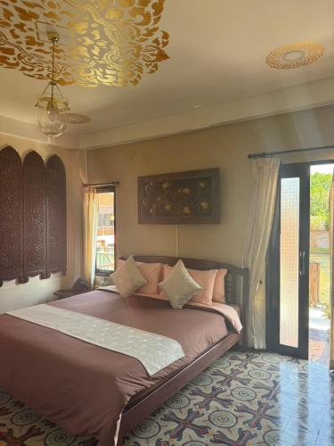 a bedroom with a large bed with a ceiling at Phutaya Wellness Retreat in Phra Nakhon Si Ayutthaya
