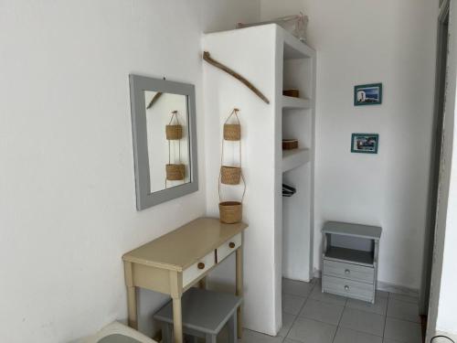 een badkamer met een tafel en een spiegel aan de muur bij Villa Campos Yalos beach in Ios Chora