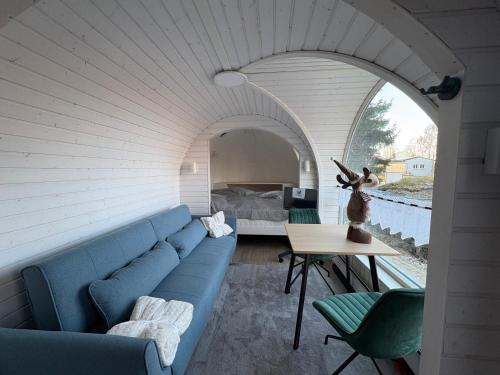 a living room with a blue couch and a table at Seeperle Weißenstadt Haus Kösseine in Weißenstadt