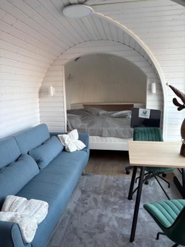 a living room with a blue couch and a bed at Seeperle Weißenstadt Haus Kösseine in Weißenstadt