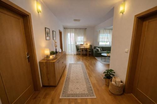 a living room with a hallway with a couch and a table at 3BR - City Views - Free Parking - Near Eurovea and Aupark in Petržalka
