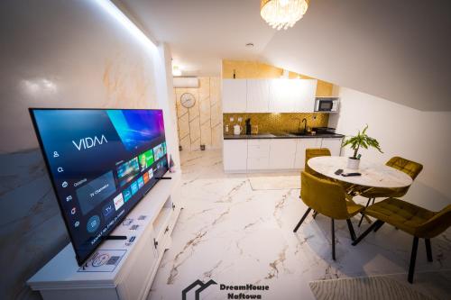 a kitchen with a large television and a table at Dream House Naftowa in Ustrzyki Dolne