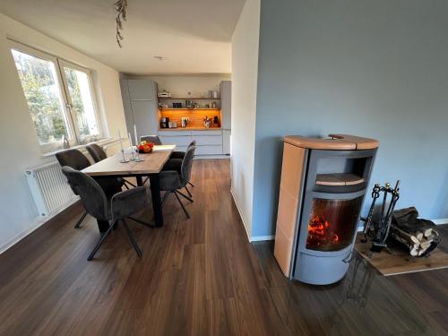 - un salon avec une table à manger et une cheminée dans l'établissement Ferienwohnung am Waldesrand, à Ahlbeck