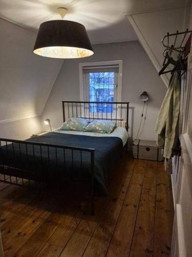 een slaapkamer met een bed onder een plafond met een licht bij Divino in Dordrecht