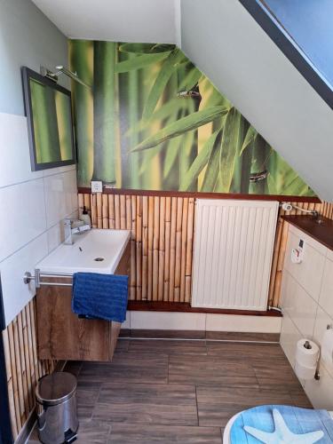 ein Badezimmer mit einem Waschbecken und einem Palmenmilch in der Unterkunft Charmante Fachwerkhaushälfte mit Sauna in Rosche