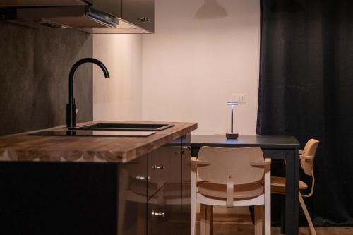 een keuken met een wastafel en een aanrecht met 2 stoelen bij Grifone Dolomiti Resort in Livinallongo del Col di Lana