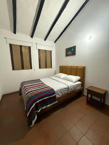 a bedroom with a bed with a blanket on it at Monguí Posada Familiar in Duitama