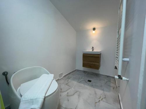 een witte badkamer met een toilet en een wastafel bij Piata Uniri Cozy Inn in Boekarest