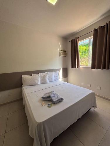 a bedroom with a bed with a towel on it at Hotel Master Plaza Formiga in Formiga