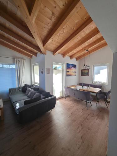 een grote woonkamer met een bank en een tafel bij Chalet Fini in Bramberg am Wildkogel