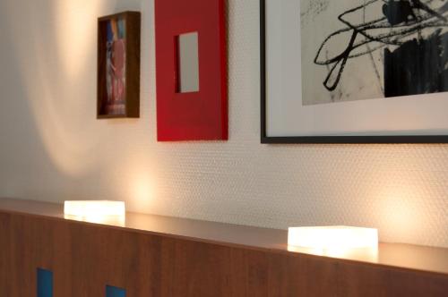 two lights on a counter in a room with pictures at The Originals Boutique, Hôtel Le Pariou, Issoire in Issoire