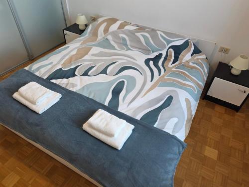 a bedroom with a bed with two towels on it at Apartmaji Trije Valovi in Piran