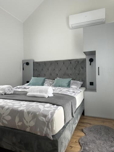 ein Schlafzimmer mit einem großen Bett und blauen Kissen in der Unterkunft SkyView Wierch Private Jacuzzi Mountain View in Ząb